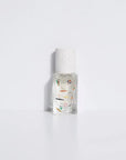 A Maison Matine Perfume by Faire, featuring a clear bottle with a white speckled cap and small colorful illustrations of people swimming and relaxing, set against a plain white background.