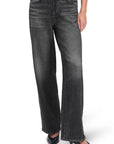 A person wears Rag & Bone's miramar terry drwcrd wide pant—high-waisted, loose-fit, black washed pants with an elastic waist and front pockets—paired with black pointed-toe heels. The cropped photo highlights the pants and shoes.