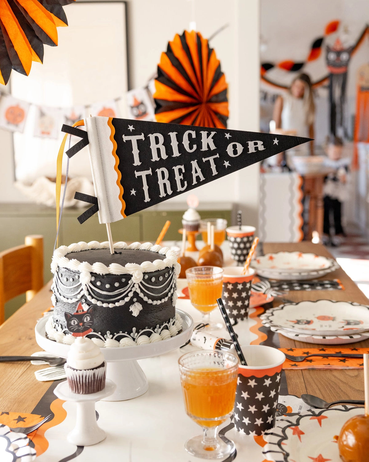 Black and white Halloween cake on styled table with vintage decor, Bungalow Furniture &amp; Accessories ambiance.
