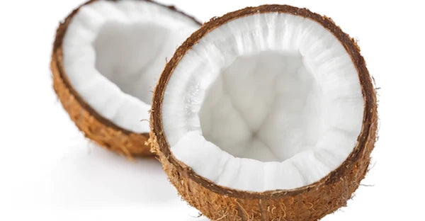 Two halves of a brown coconut with white flesh are shown on a white background, highlighting the natural source of Faire Monoi Coco Coconut Oil. The rough shell and smooth interior illustrate its pure, nourishing origin.