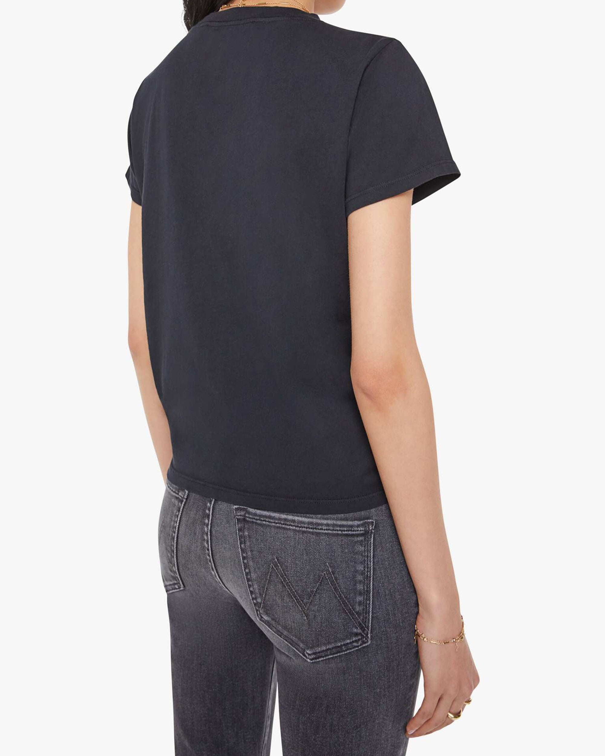 A person is shown from the back wearing Mother’s The Lil Goodie Goodie Tee, known for its super soft fabric and vintage look, paired with dark gray jeans against a plain white background.