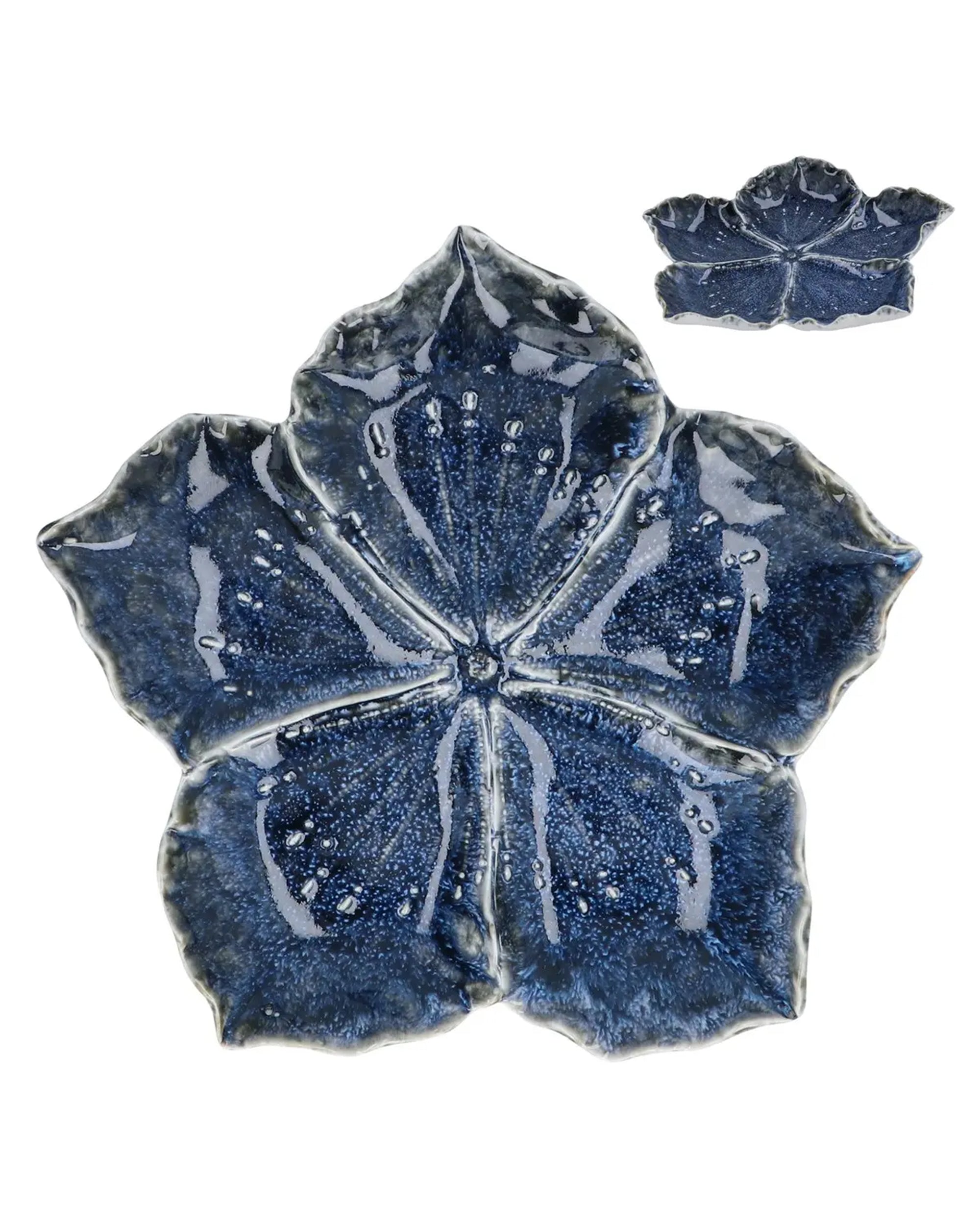 The Faire Blue Stoneware Hibiscus Trinket Dish L is a glossy, dark blue leaf-shaped plate with textured veins and dotted details—perfect as a decorative trinket dish.