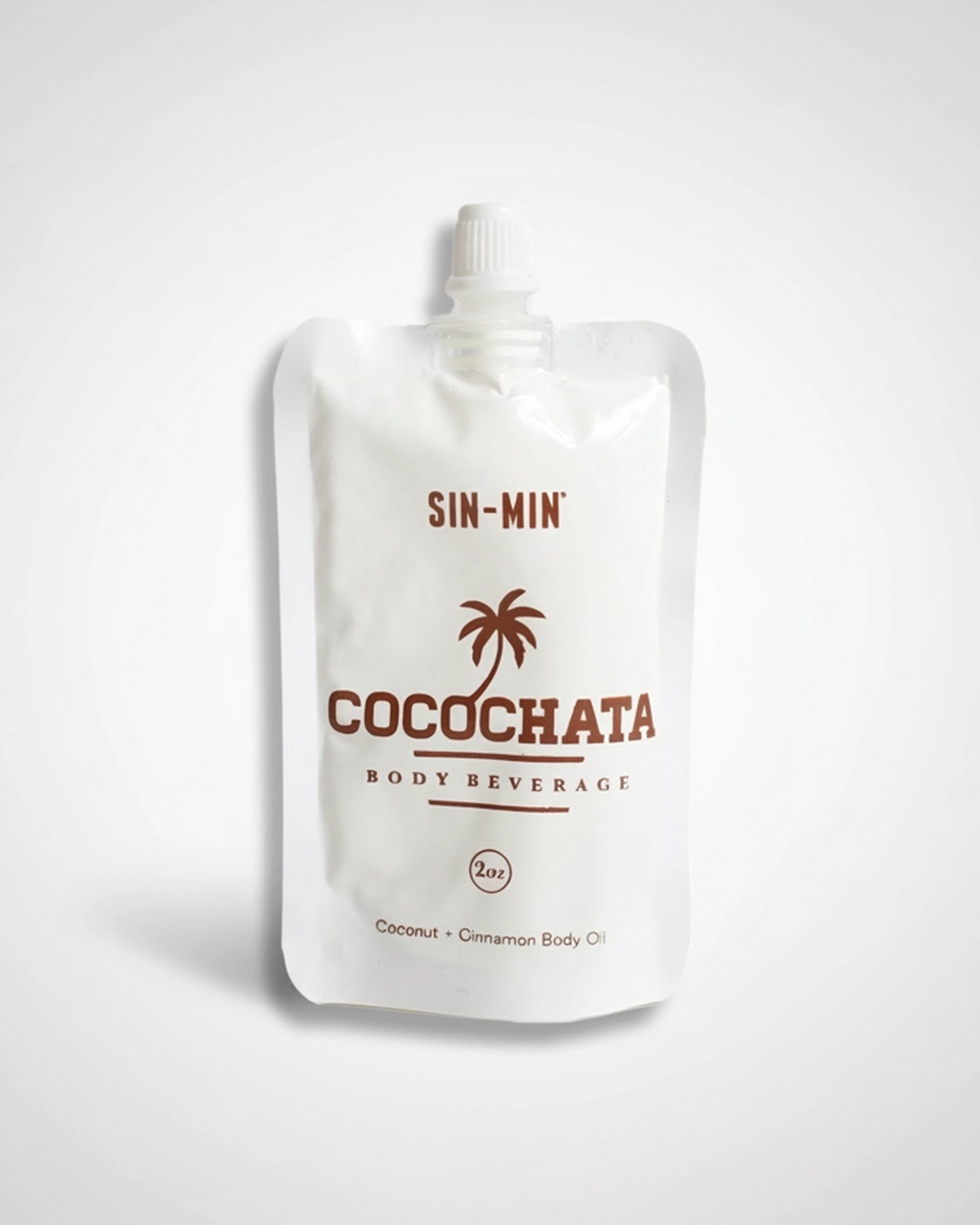 A white pouch labeled "Faire Cocochata Body Beverage" with a palm tree graphic contains 2 oz of moisturizing coconut oil, making it an ideal vegan body oil for sensitive skin, shown against a plain light background.
