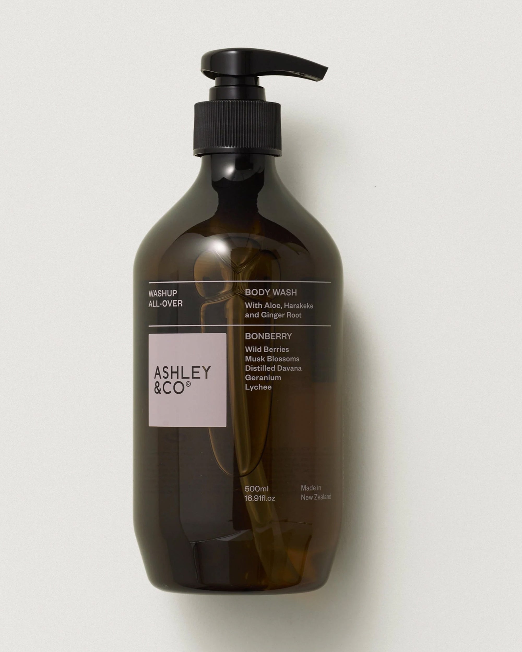 A 500ml dark amber Ashley & Co Washup/Bonberry body wash with a black pump dispenser, featuring plant-based essential oils, aloe, harakeke, ginger root, and a Bonberry scent.