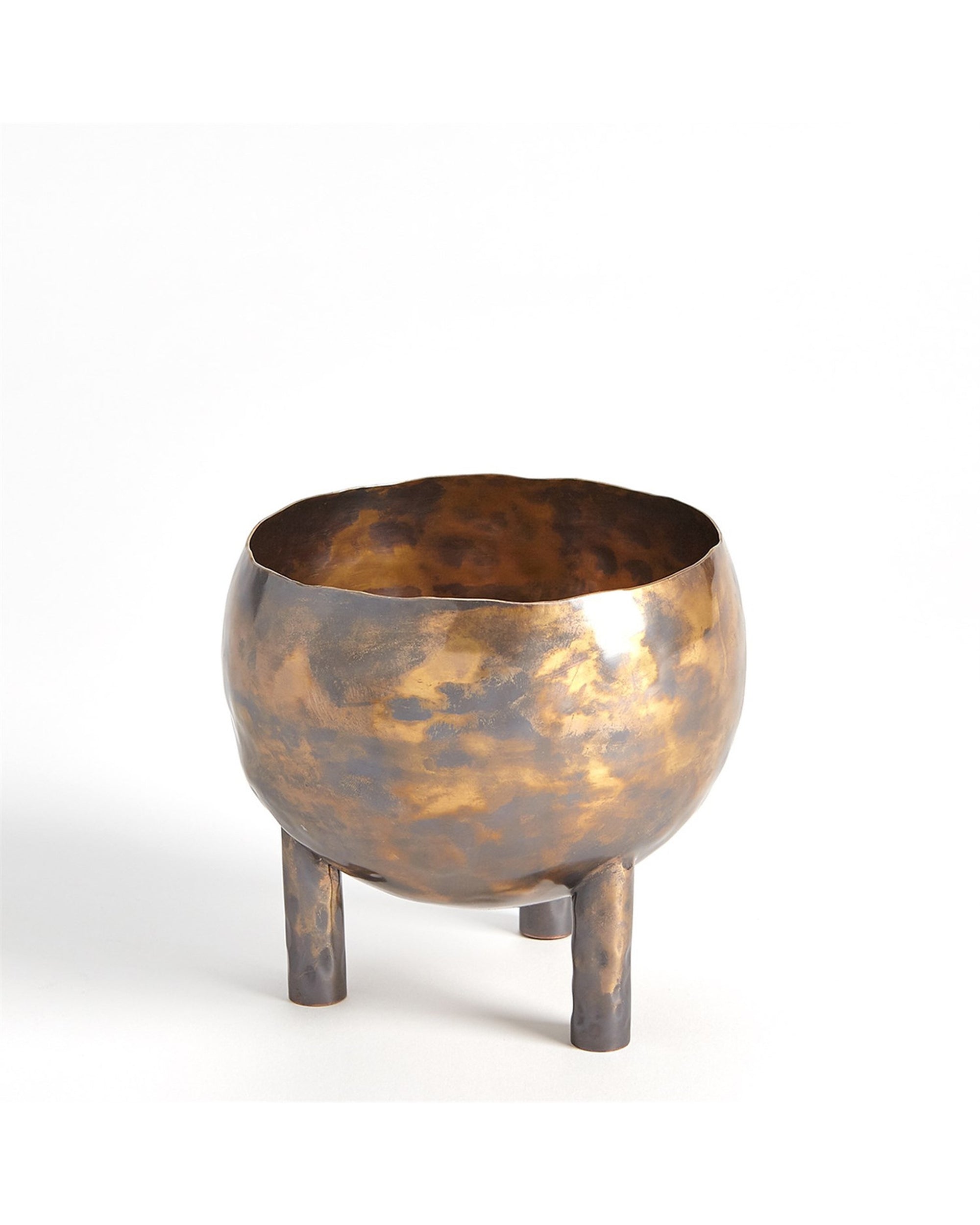 The Alchemy Container Burnt Brass S by Global Views is a round, hammered oxidized brass bowl with a golden-bronze patina on three cylindrical legs, shown against a plain white background.