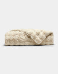The Cozy Earth Bubble Cuddle Blanket, in cream, is folded on a light gray background, highlighting its ultra-soft faux fur texture.