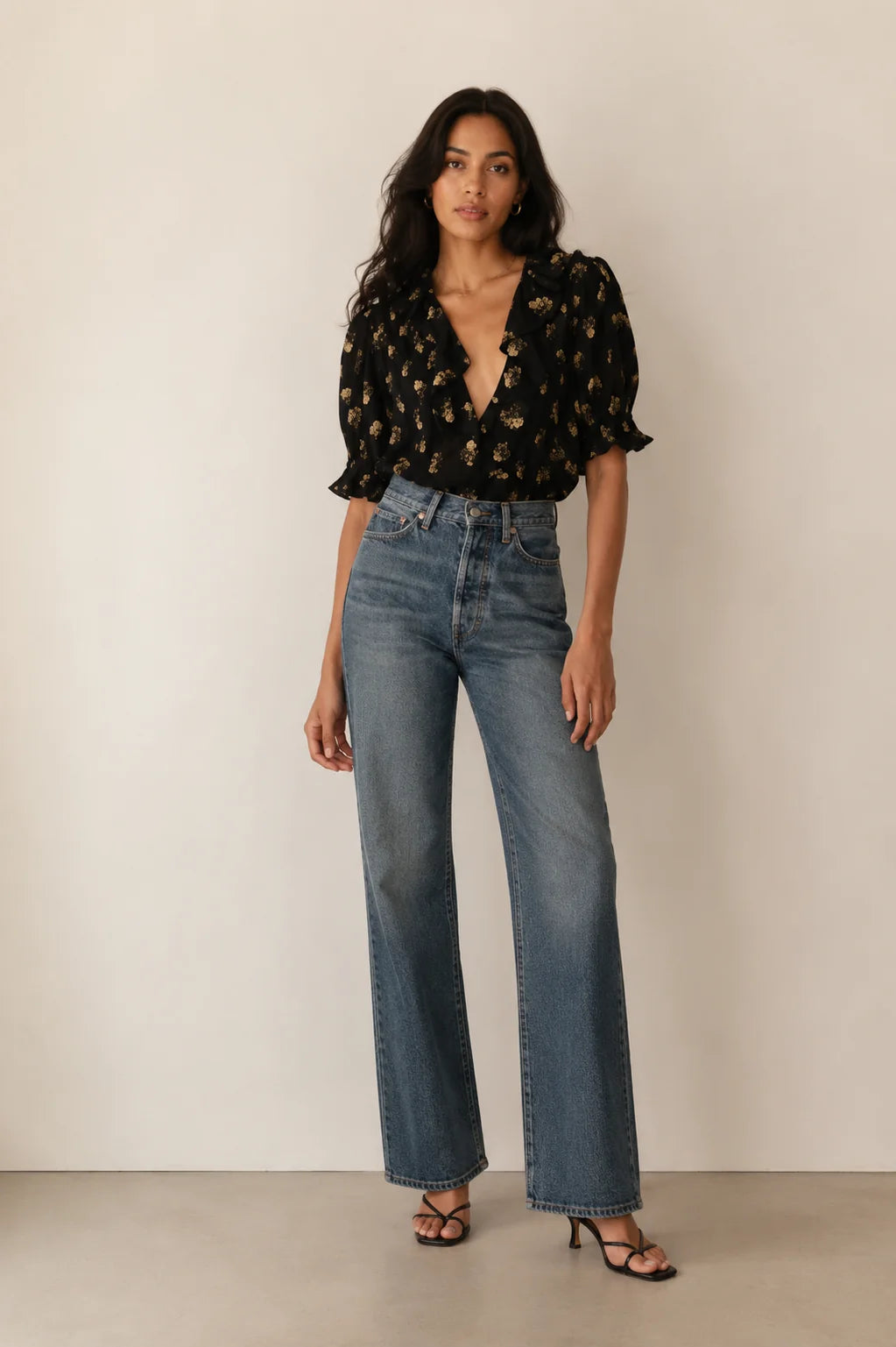 DOEN Henri top styled with high-waisted blue jeans and black heels, set against a simple light background.