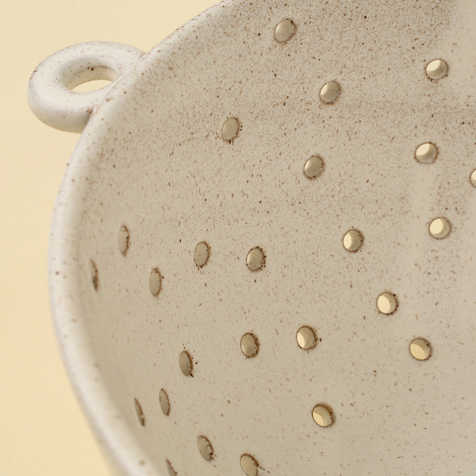 Riverstone Berry Bowl L with handle and drainage holes by Faire, artisanal stoneware for kitchen or dining use.