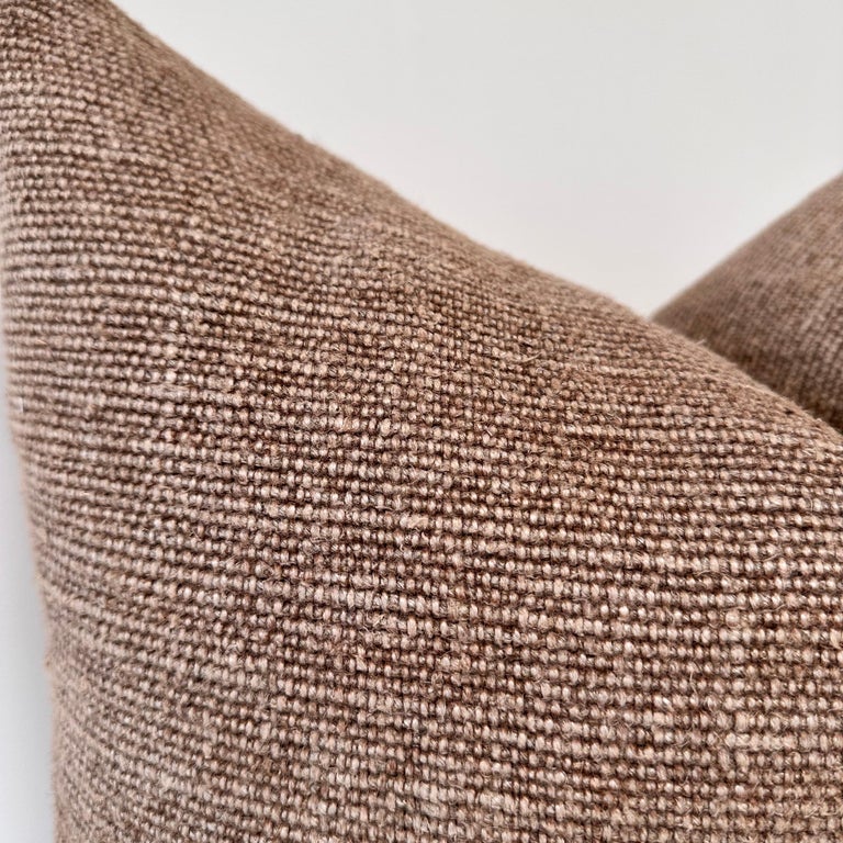 Close-up of the Faire Alora Woven Linen Havana pillow, featuring textured brown fabric and a plush down feather insert, set against a plain white background.