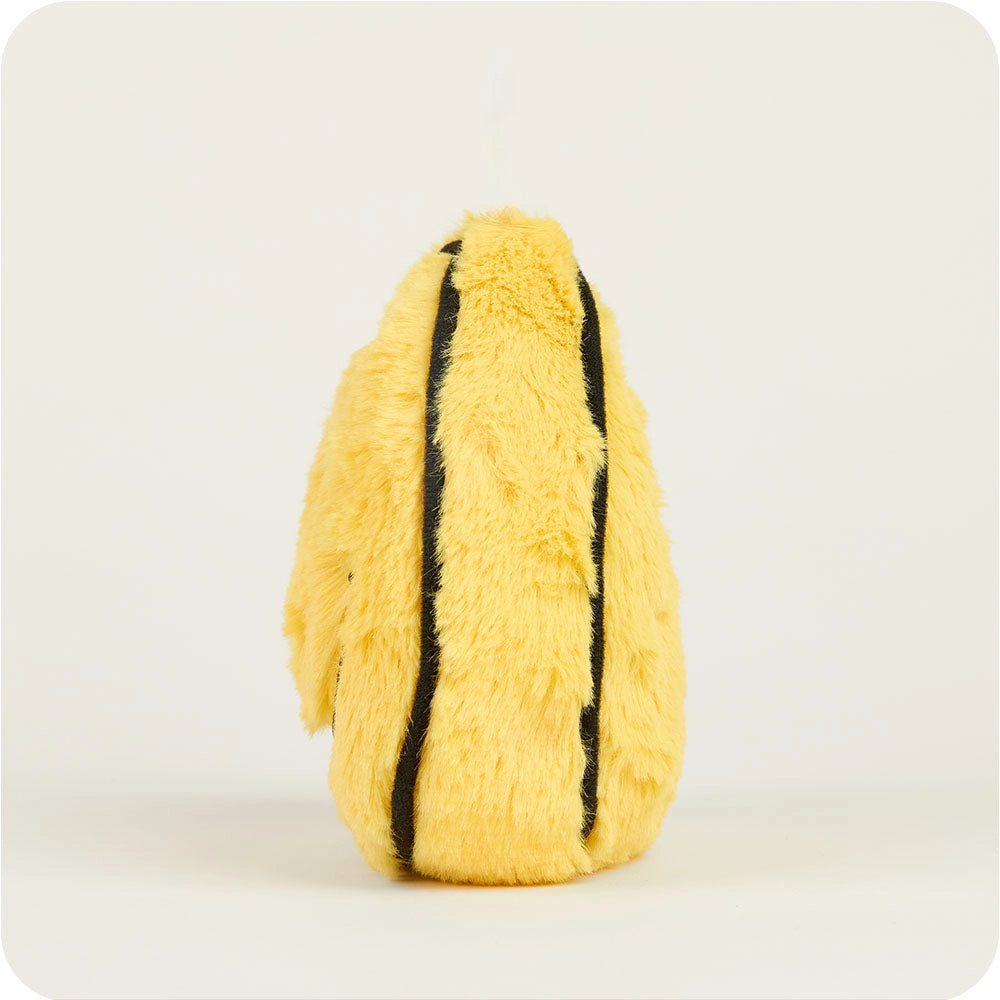 The Faire Smiley Face Warmies Junior is a microwavable plush toy shaped like a yellow oval with two black stripes. Soft and fuzzy, it offers sensory comfort and stands upright with no visible face, photographed against a plain light background.