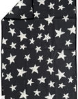 The Faire "Hand Towel : Into The Stars" is a black rectangular waffle weave microfiber towel with white stars of various sizes. A folded corner shows that the same star pattern appears on both sides.