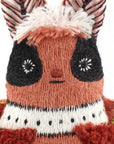 Close-up of a handmade plush moth crafted with the Faire Moth Embroidery Kit, showcasing embroidered facial features, large black eyes, striped antennae, and green wings adorned with red and black accents.