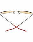 Caddis Mabuhay Matte Black sunglasses feature yellow tinted lenses and thin wire aviator arms, shown from the back with red rubber temple tips crossed at the bottom against a white background.