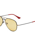 The Mabuhay Matte Black by Caddis are wire frame aviator sunglasses with yellow-tinted lenses and red rubber temple tips, shown on a white background.