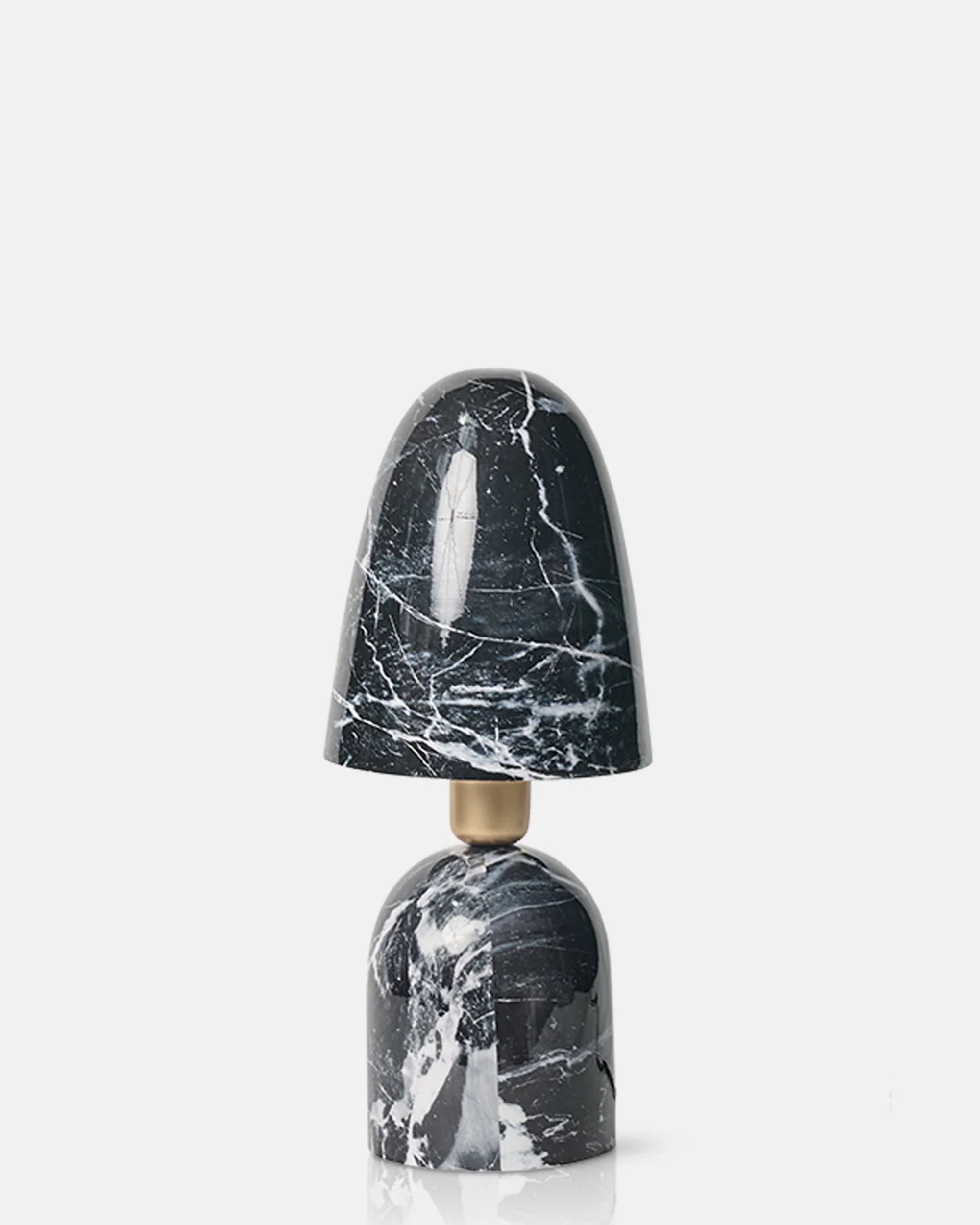 The Caswell Table Lamp by Abigail Ahern features a modern black design with a black and white marble finish base and shade, natural veining patterns, and a gold neck accent, set against a plain white background.