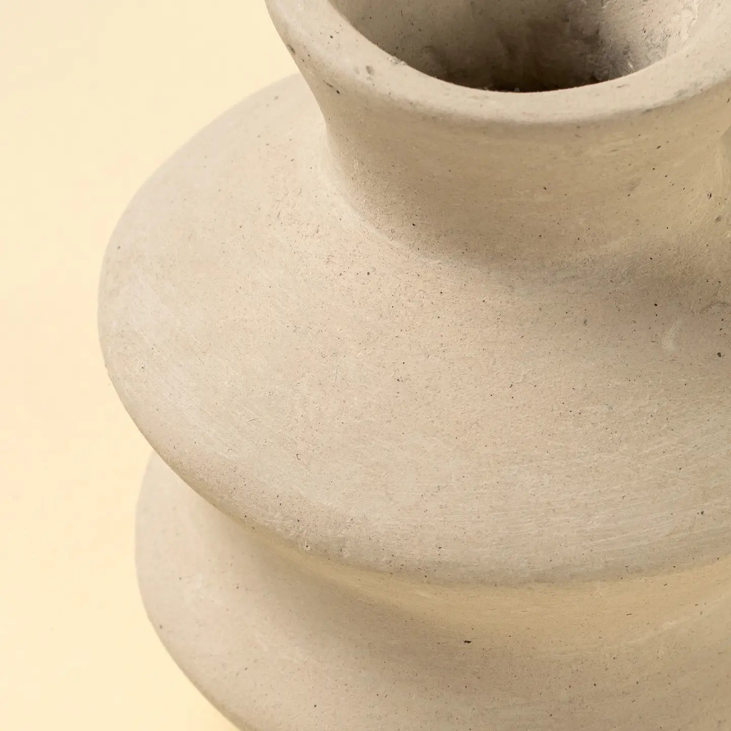 Close-up of the Indaba Wave Paper Mache Bud Vase—a light beige, handcrafted piece with a wide body and narrow neck. Set against a soft cream background, it showcases its smooth matte finish and sustainable design for elegant home decor.