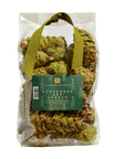 A clear plastic bag of Potpourri Pine Cones by Faire, featuring dried botanicals scented with pine and cedar, a green ribbon handle, and a green label on the front.