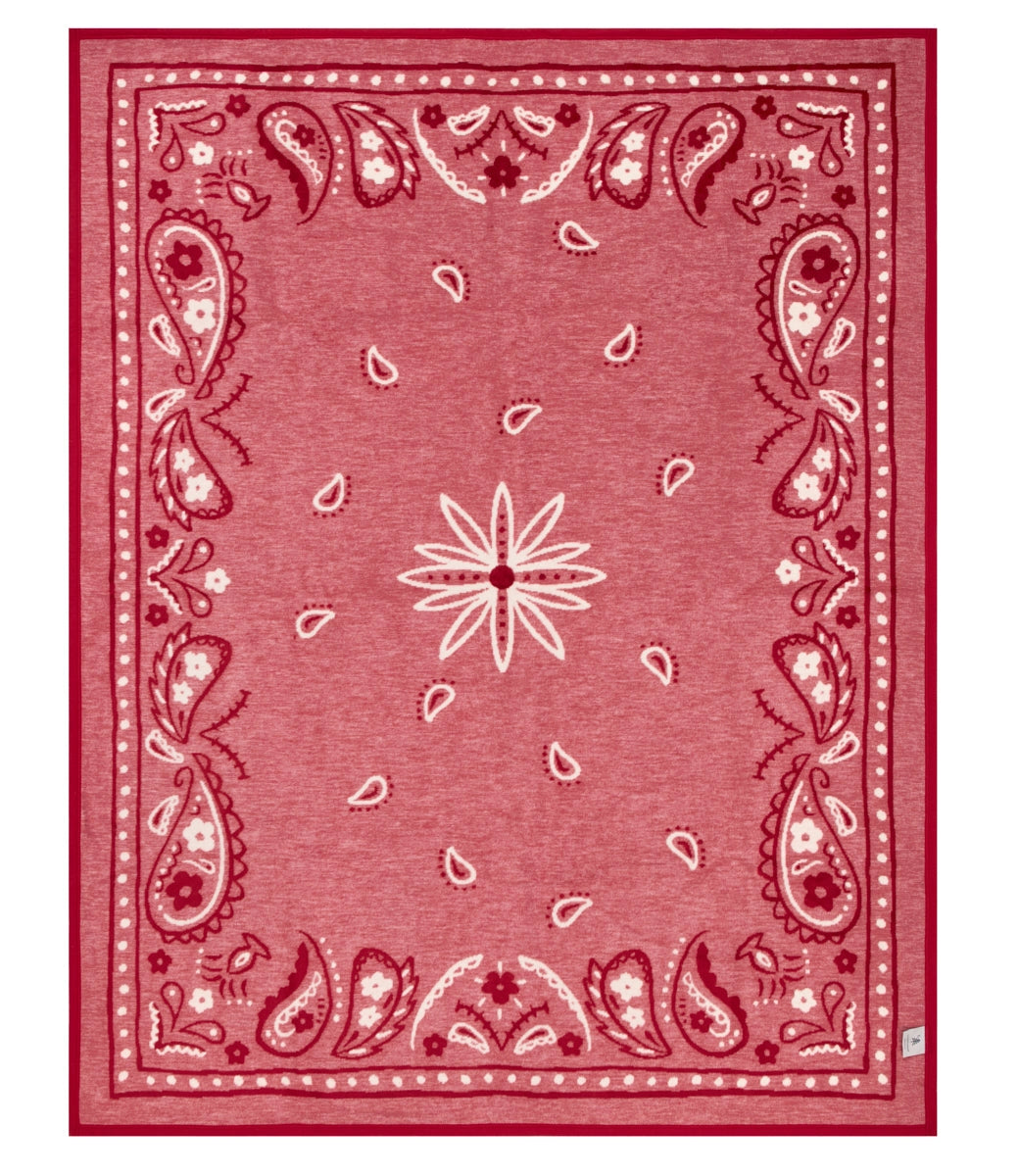 The Vintage Bandana Blanket by Faire features a rectangular red design with white and burgundy paisley, teardrop shapes, and a central star motif, blending classic Americana spirit with nostalgic print.