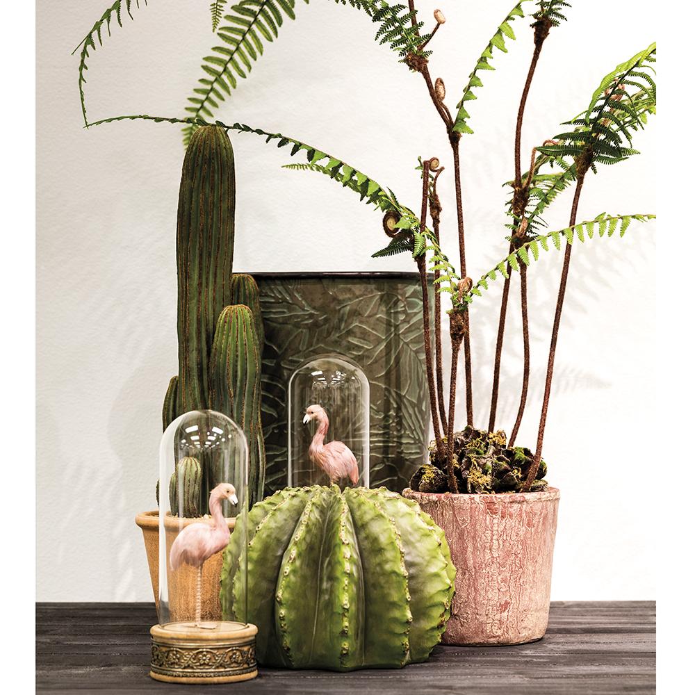 A decorative display featuring the AllState Floral And Craft COLUMN CACTUS 26" with potted ferns and two glass domes holding pink flamingo figurines, arranged on a dark wooden surface against a light background.