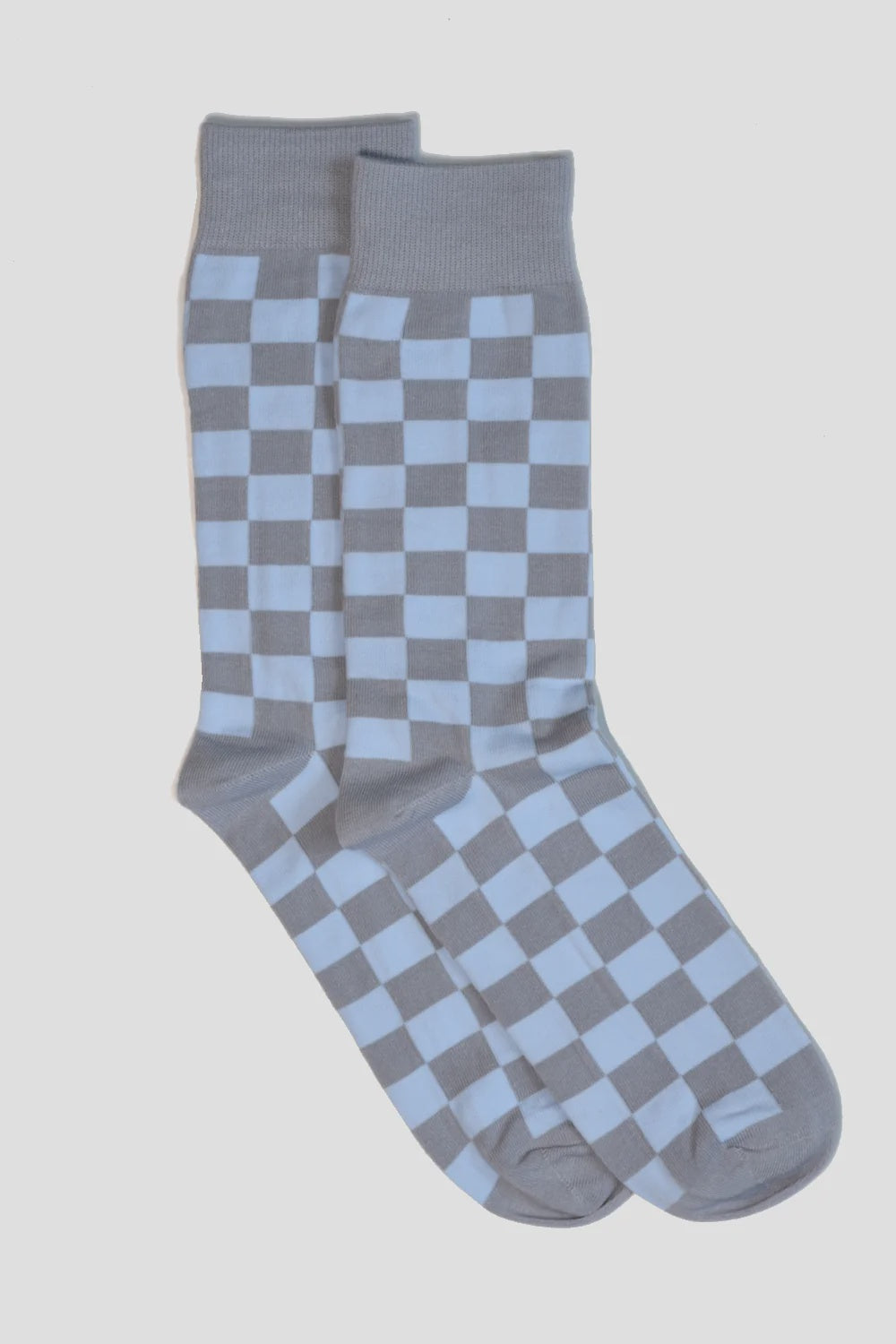 The MENS Blue Checker Socks by Curated Basics showcase a light blue and gray checkerboard pattern on a solid background, providing comfort with seamless toes. They are expertly designed for wearers adhering to US size standards.