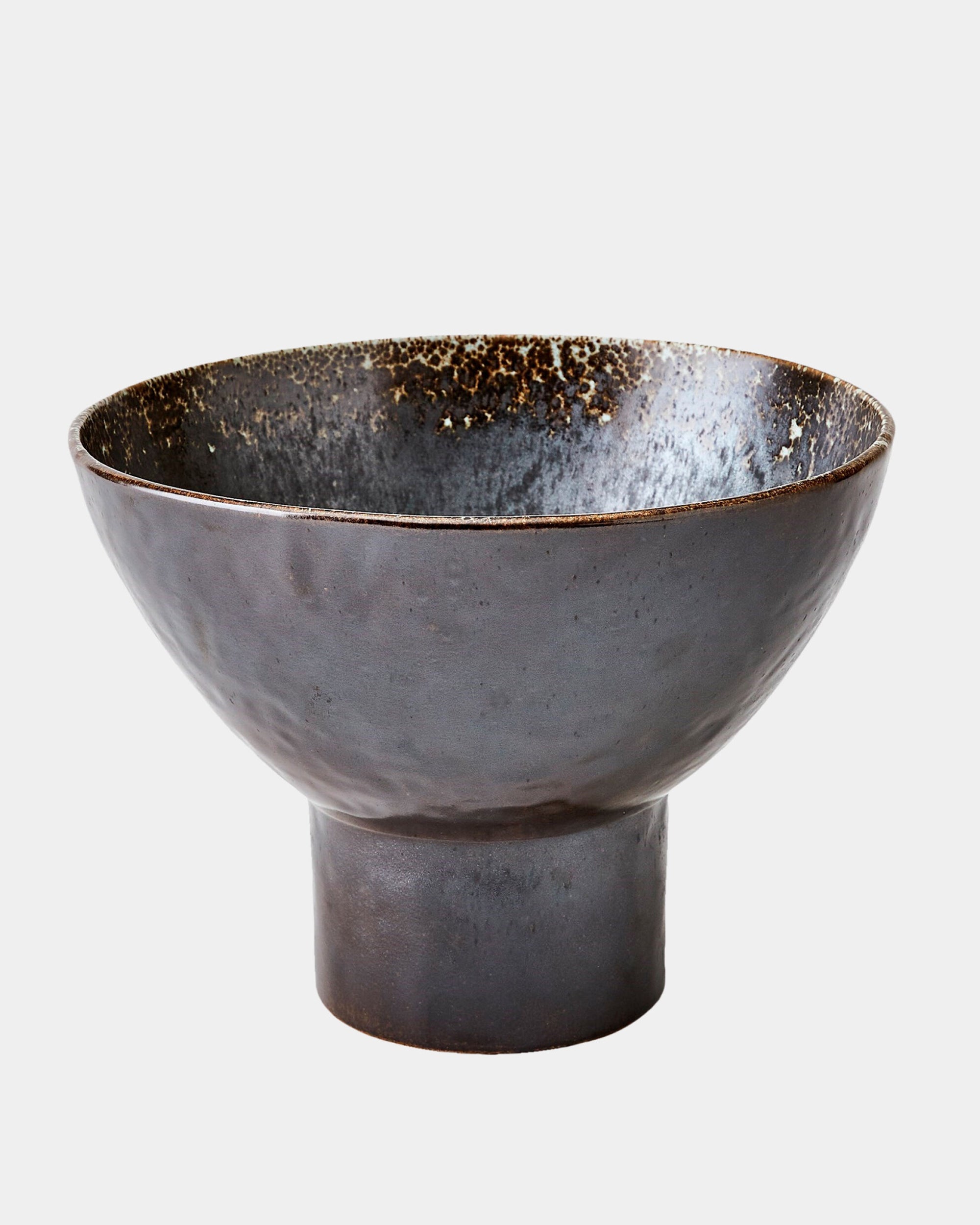 The Cinder Footed Bowl by Global Views is a wide, dark Portuguese stoneware bowl with a speckled interior and smooth raised base, highlighting handcrafted artistry. Shown on a plain white background.