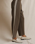 Perfectwhitetee Claud Track Pant styled with white loafers, shown against a soft cream fabric backdrop.