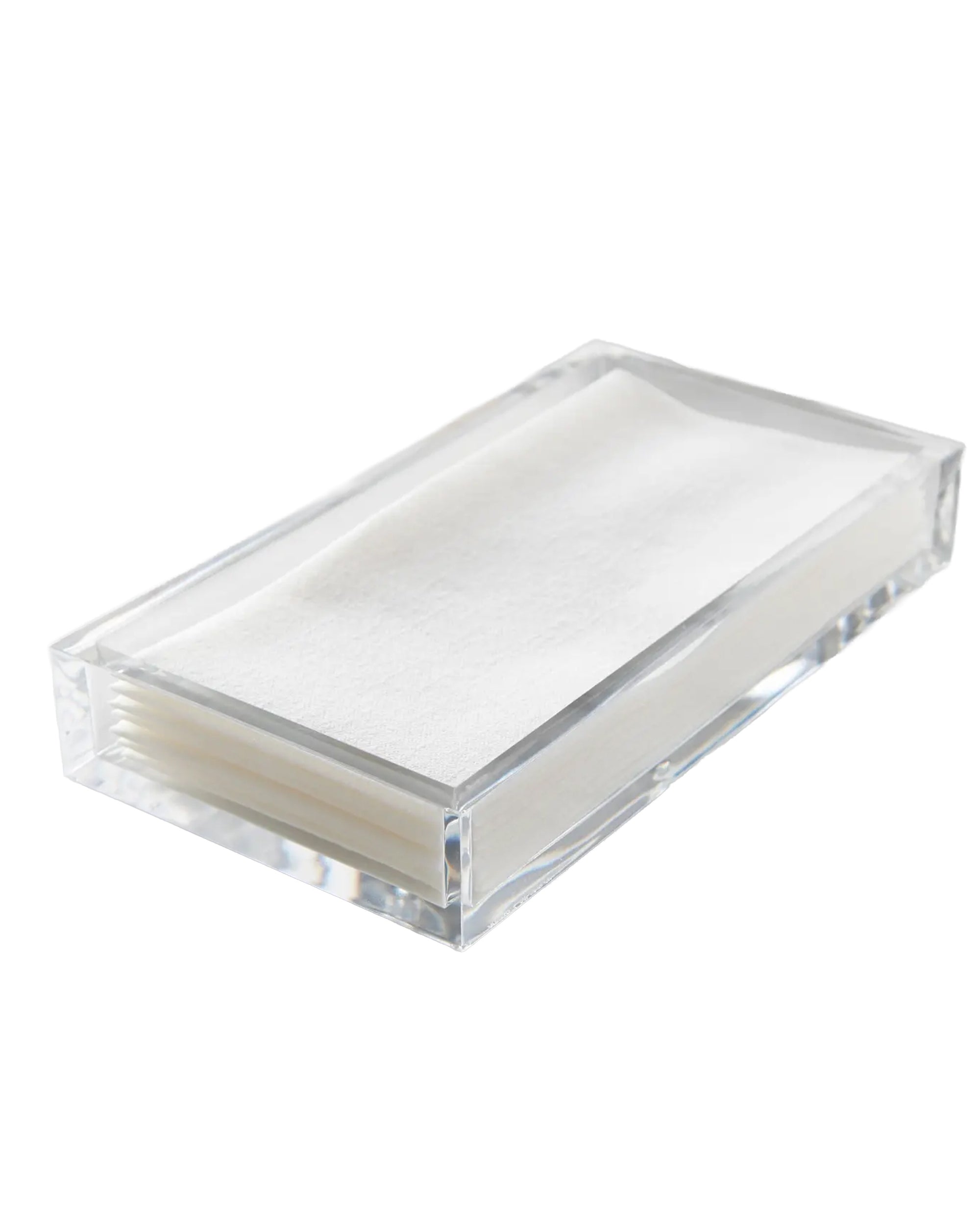 The Faire Thick Tray Dinner Napkin set features a sleek acrylic tray holding a stacked arrangement of white napkins, displayed at an angle on a clean white background.