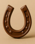 The Faire Chocolate Horseshoe stands upright on a beige background, symbolizing good luck. Made in the United States.