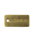 The HomArt Brass Tag is a rectangular hand-stamped brass gift tag with rounded edges, "CONGRATS" in uppercase, and a small left-side hole—ideal for adding a sentimental touch to your gift.