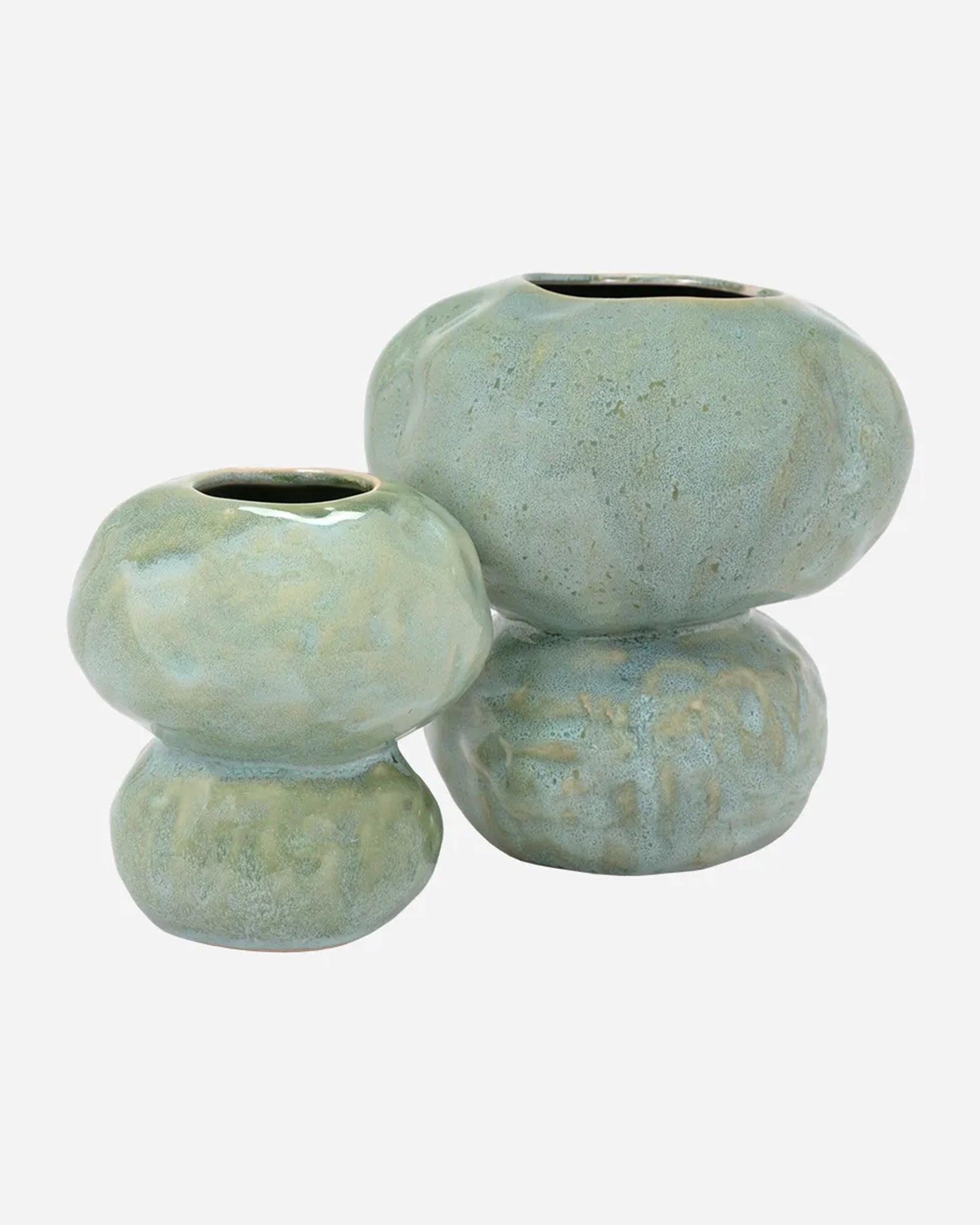 The Import Collection’s Connolly Vase set features two handcrafted ceramic vases in light green with textured glaze, each irregularly shaped and rounded, including a small and a large piece with narrow top openings.