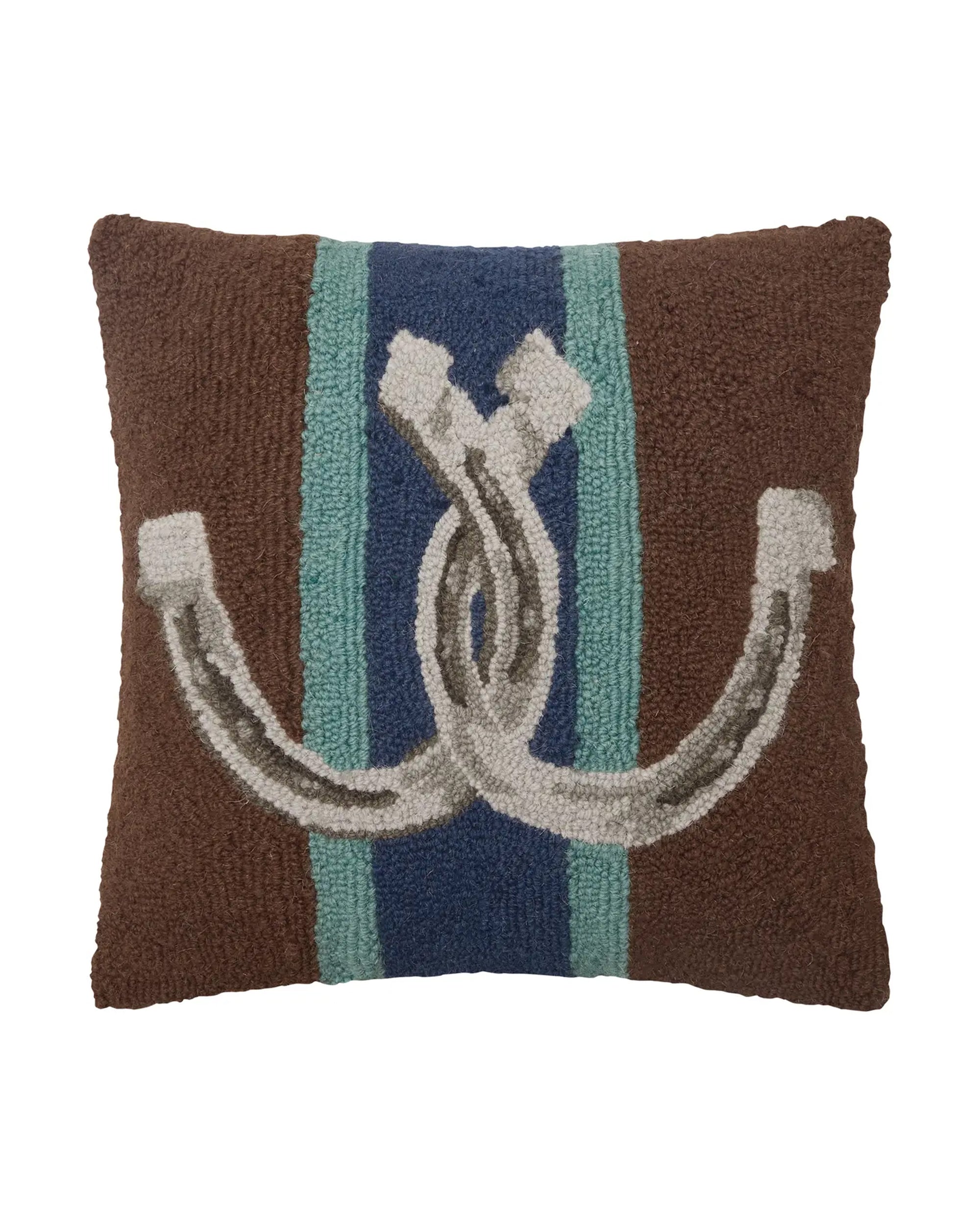 The Country Club Pillow by Faire is a rectangular brown throw pillow with a blue vertical stripe bordered by light blue, featuring hooked wool accents of intertwined gray and white ropes in the center.