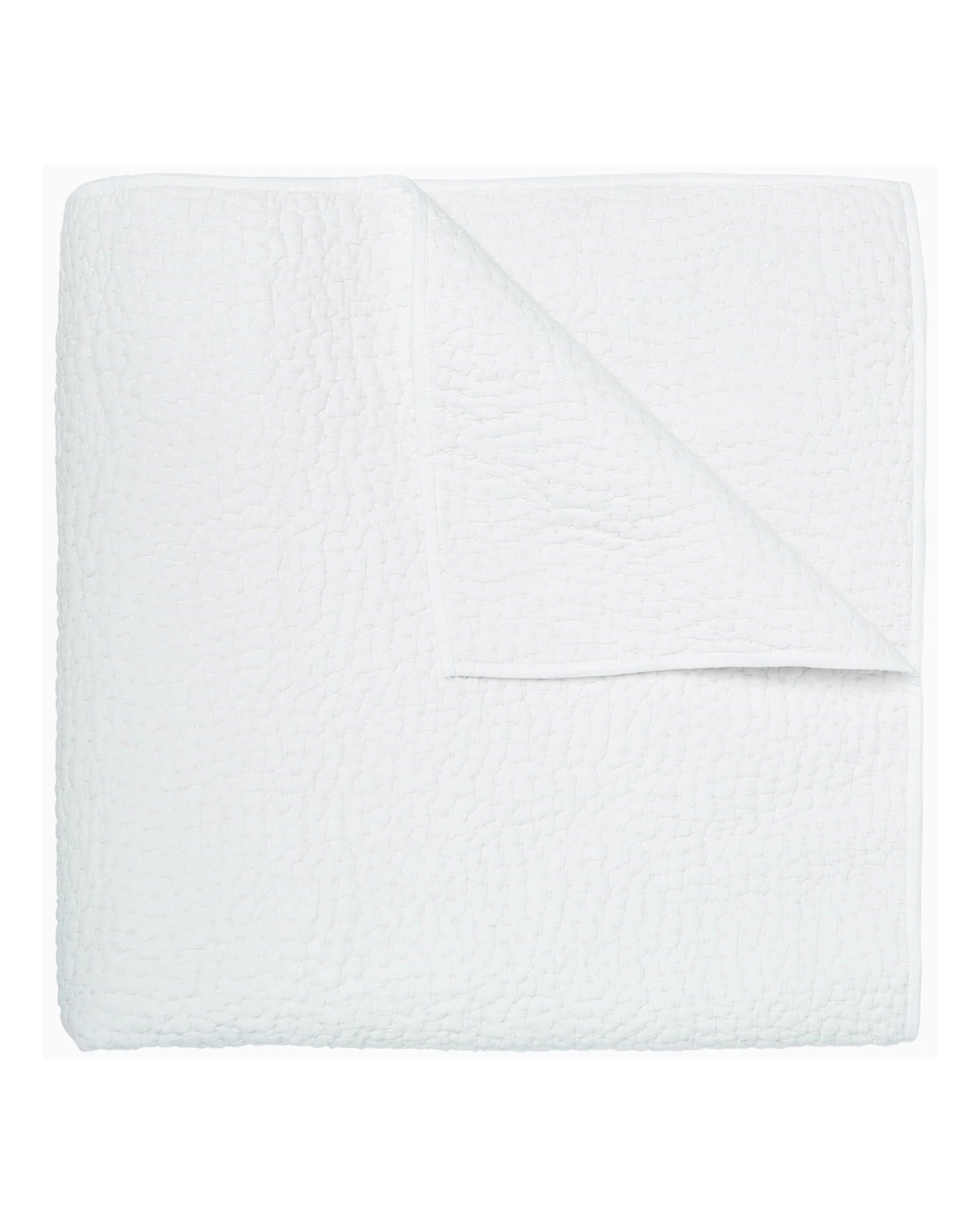 The John Robshaw Coverlet Queen is a folded white quilt featuring a textured pattern and reversible design, with one corner turned down to display the organic cotton underside.