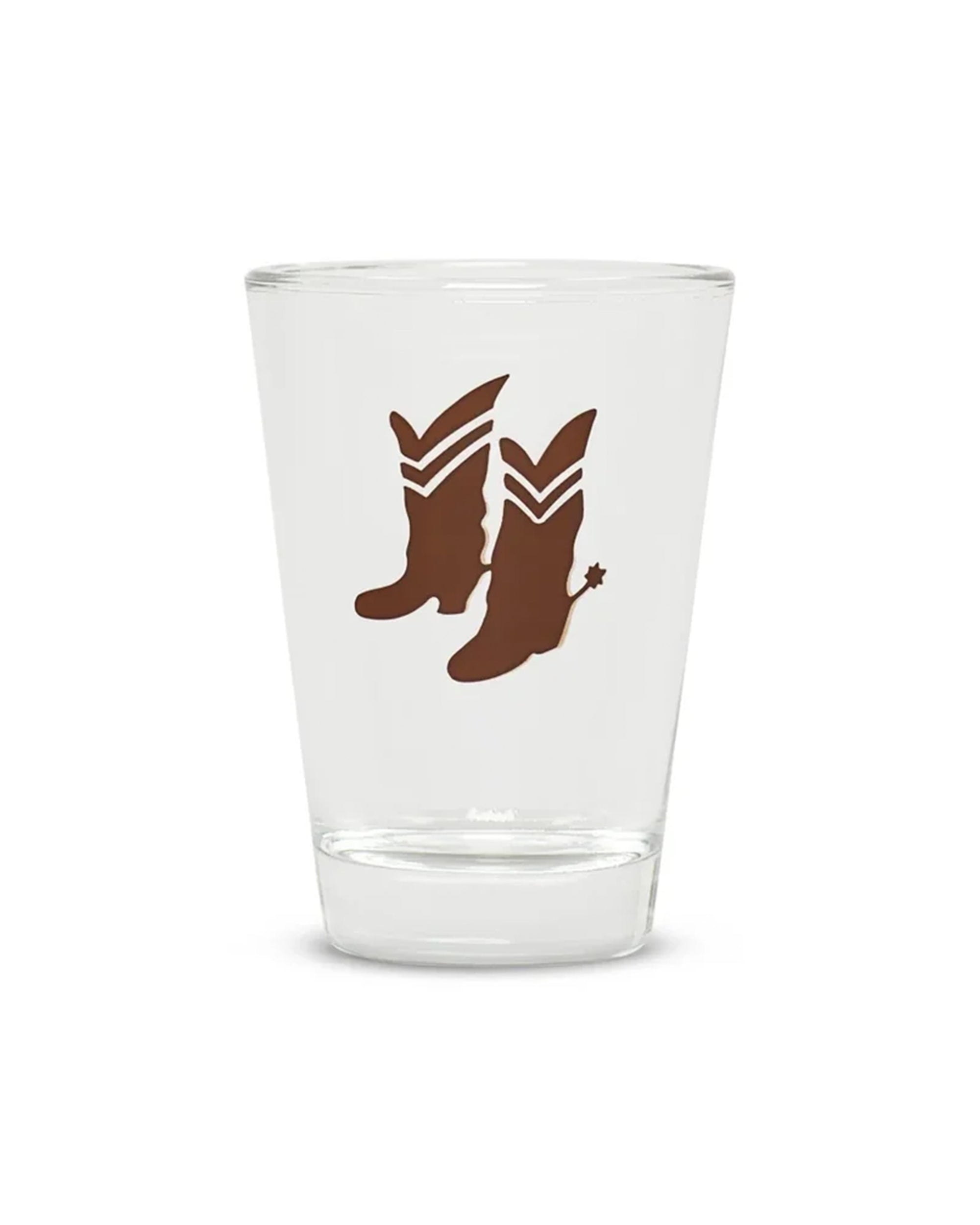 Brown cowboy boots with spurs on clear glass, Fishes Eddy Cowboy Boots Shot Glass, perfect for barware collections.