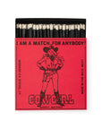 An open red AG Safety Matches box by Faire, showing black matchsticks with white tips. Features a cowgirl and "I AM A MATCH FOR ANYBODY! COWGIRL SAFETY MATCHES." Great for gifts or collectors. Contains approx. 25 sticks.
