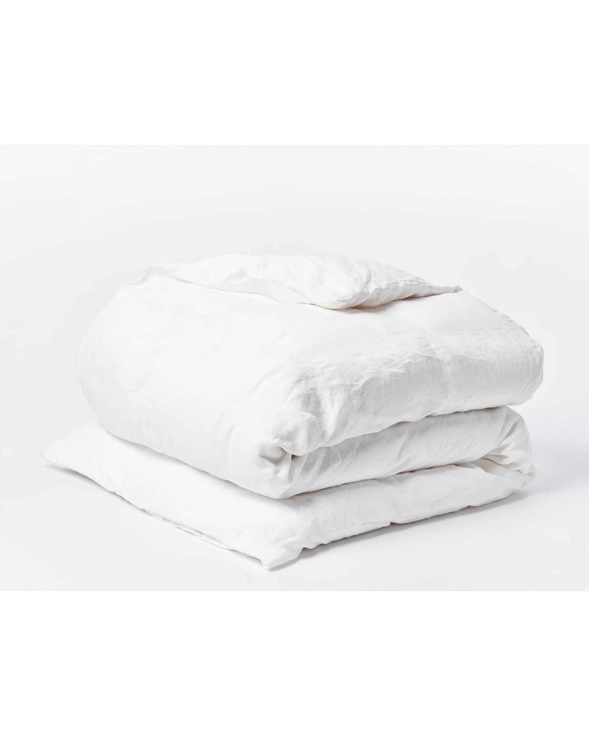 The Coyuchi Inc Org Relaxed Linen Duvet in Alpine White (Queen), crafted from organic linen and colored with low-impact dyes, is neatly folded on a white surface against a plain white background.