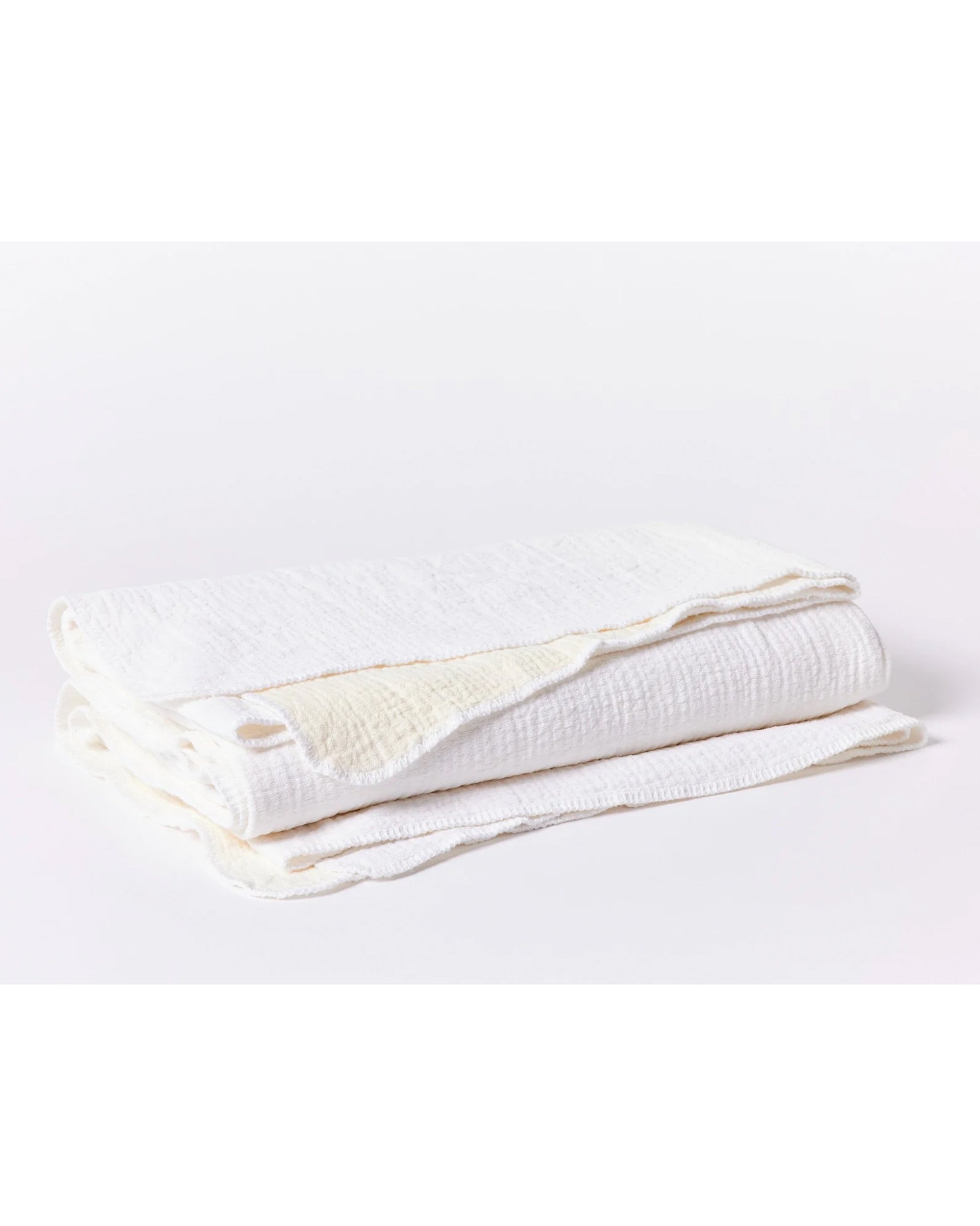 The Cozy Cotton Org. Blanket Alpine White Queen by Coyuchi Inc is an organic cotton blanket with a soft muslin texture, shown folded on a plain white background.