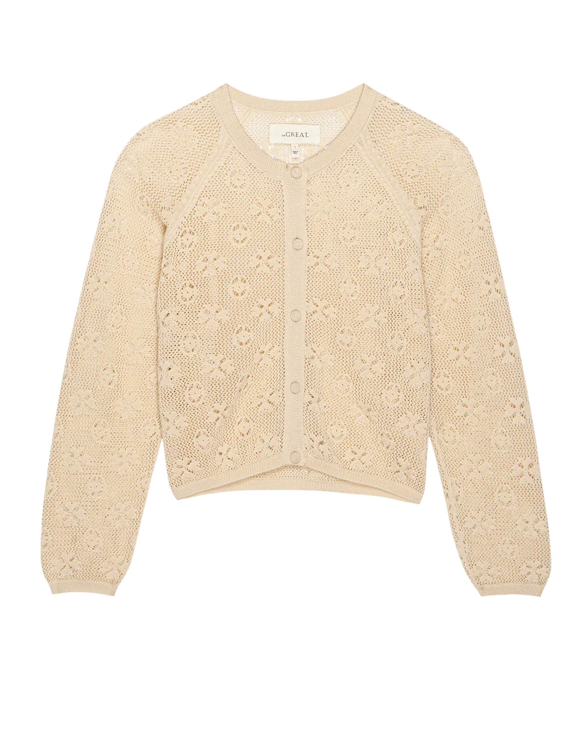 The Great Inc.'s The Crochet Cardigan is a beige vintage-style piece with long sleeves, round neckline, button-down front, floral lace-like crochet pattern, and ribbed cuffs, hem, and collar.