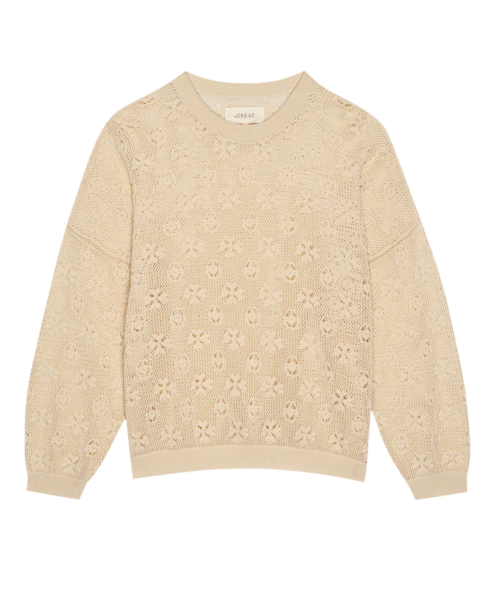 The Crochet Pullover by The Great Inc.—a beige long-sleeve sweater with a floral lace pattern and ribbed cuffs, hem, and neckline—displayed flat on a white background.