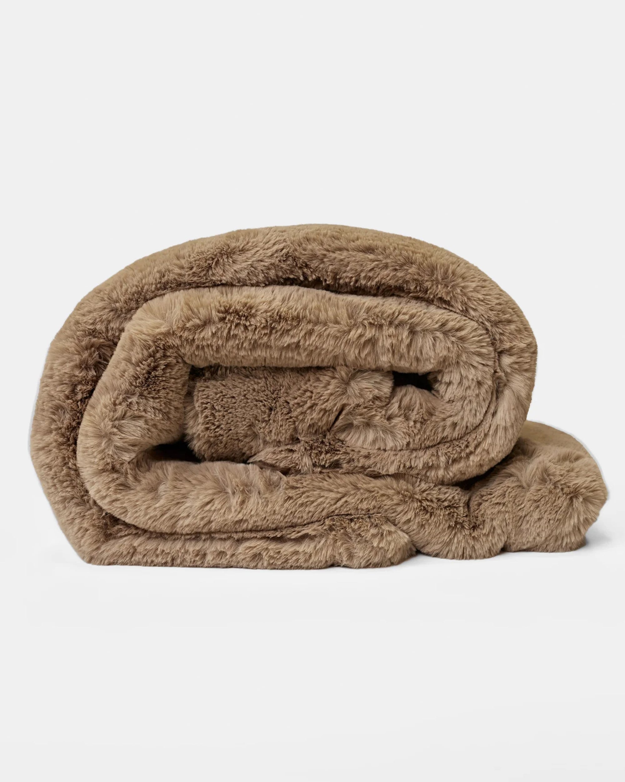 The Cuddle Blanket by Cozy Earth, an ultra-plush light brown faux fur throw, is neatly rolled up on a plain white background.