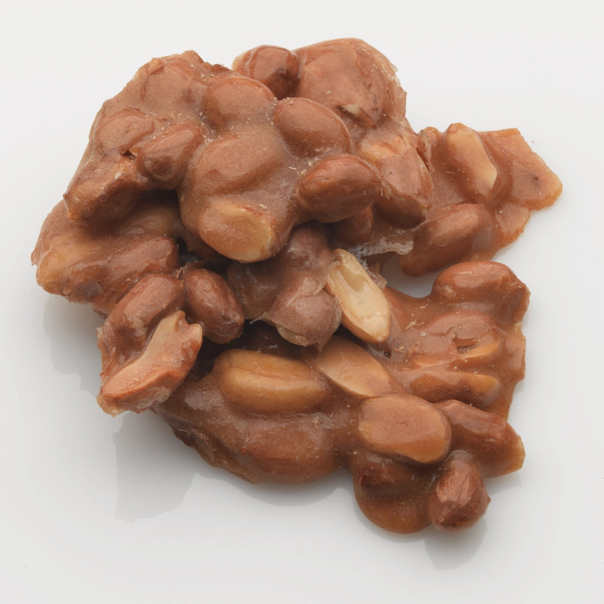 A close-up of Faire's LC Peanut Brittle 12oz on a white background, highlighting the irresistible appeal of this crunchy snack.