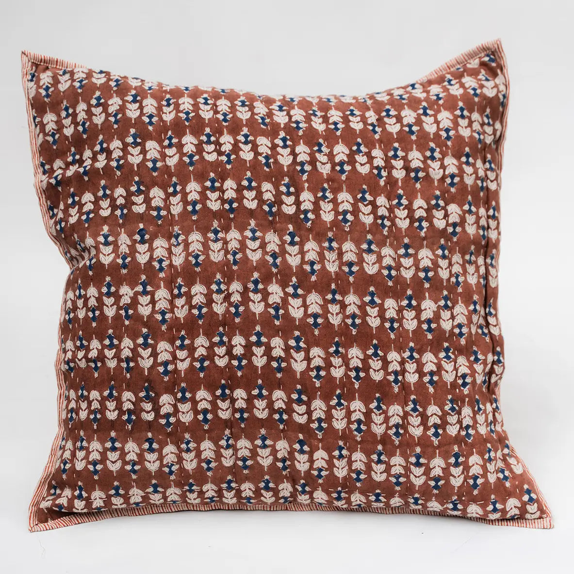 The Faire Blossom Block Print Euro Sham features a brown background with a repeating pattern of small white, blue, and black floral shapes and striped trim—perfect for adding artisan-crafted charm to your bohemian bedding ensemble.