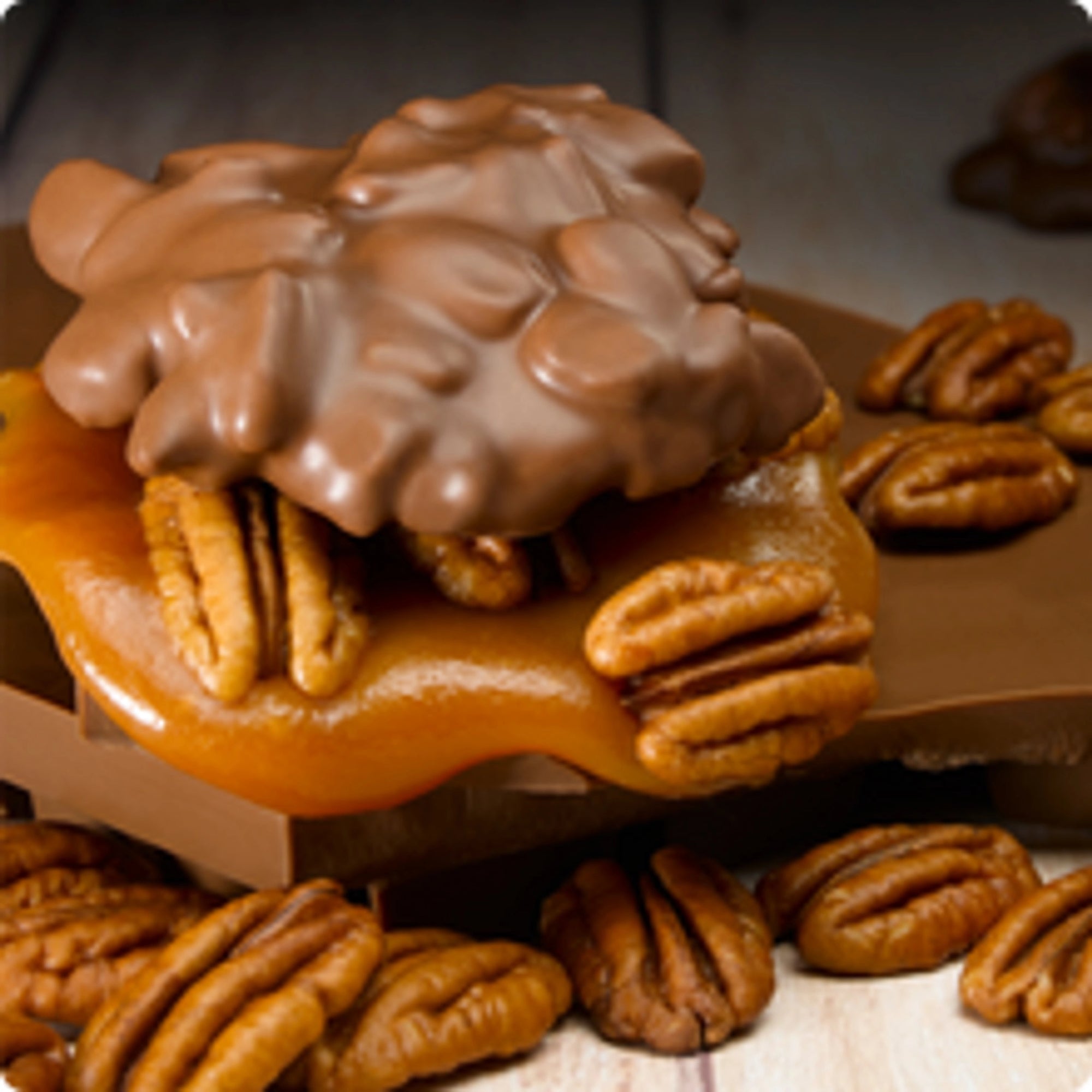 A cluster of LC Longhorns Chocolate 1.5oz by Faire—pecan caramel candy covered in milk chocolate—rests on a wooden surface amid whole pecans, offering an authentic Texas treat.