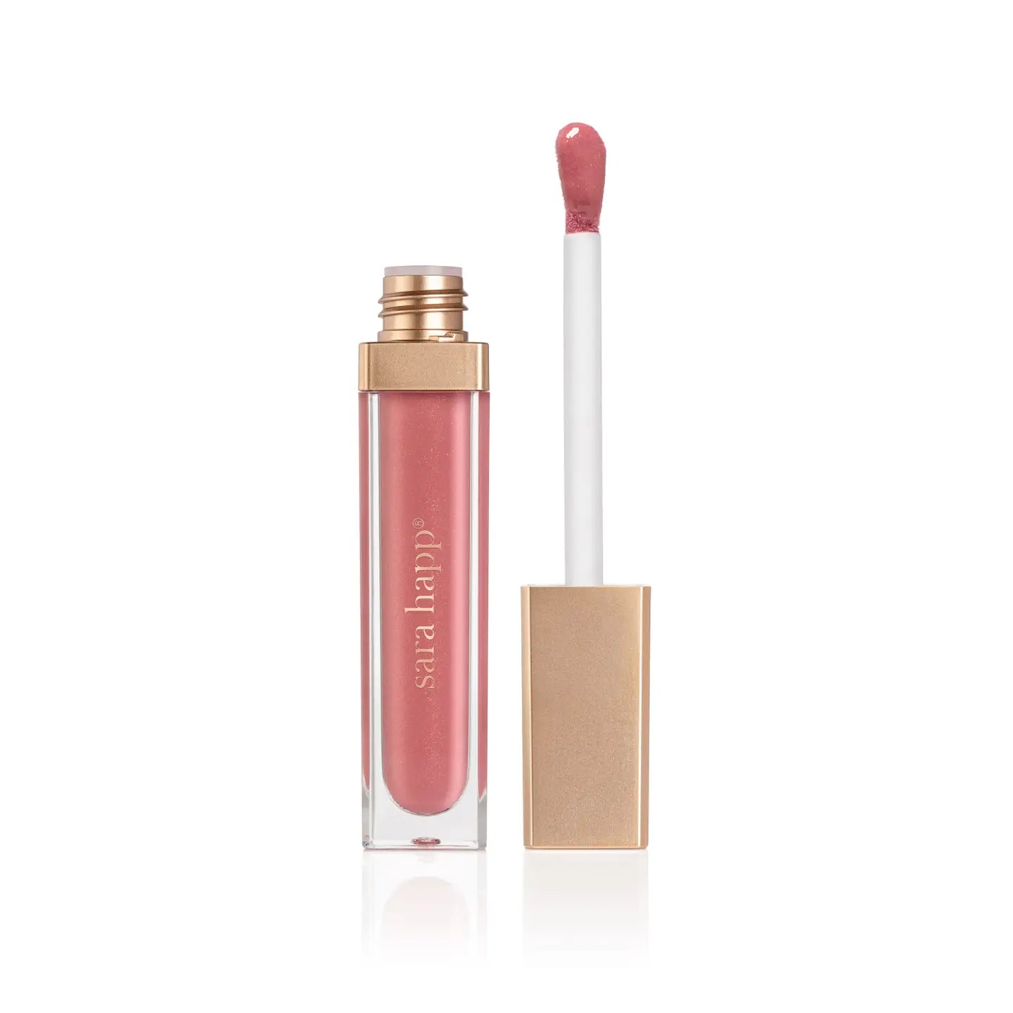 An open tube of Faire Hydrating Lip Gloss with a gold cap showcases the applicator wand coated in glossy pink. Standing against a white background, the transparent tube exudes elegance similar to a jojoba oil-infused tinted moisturizer.