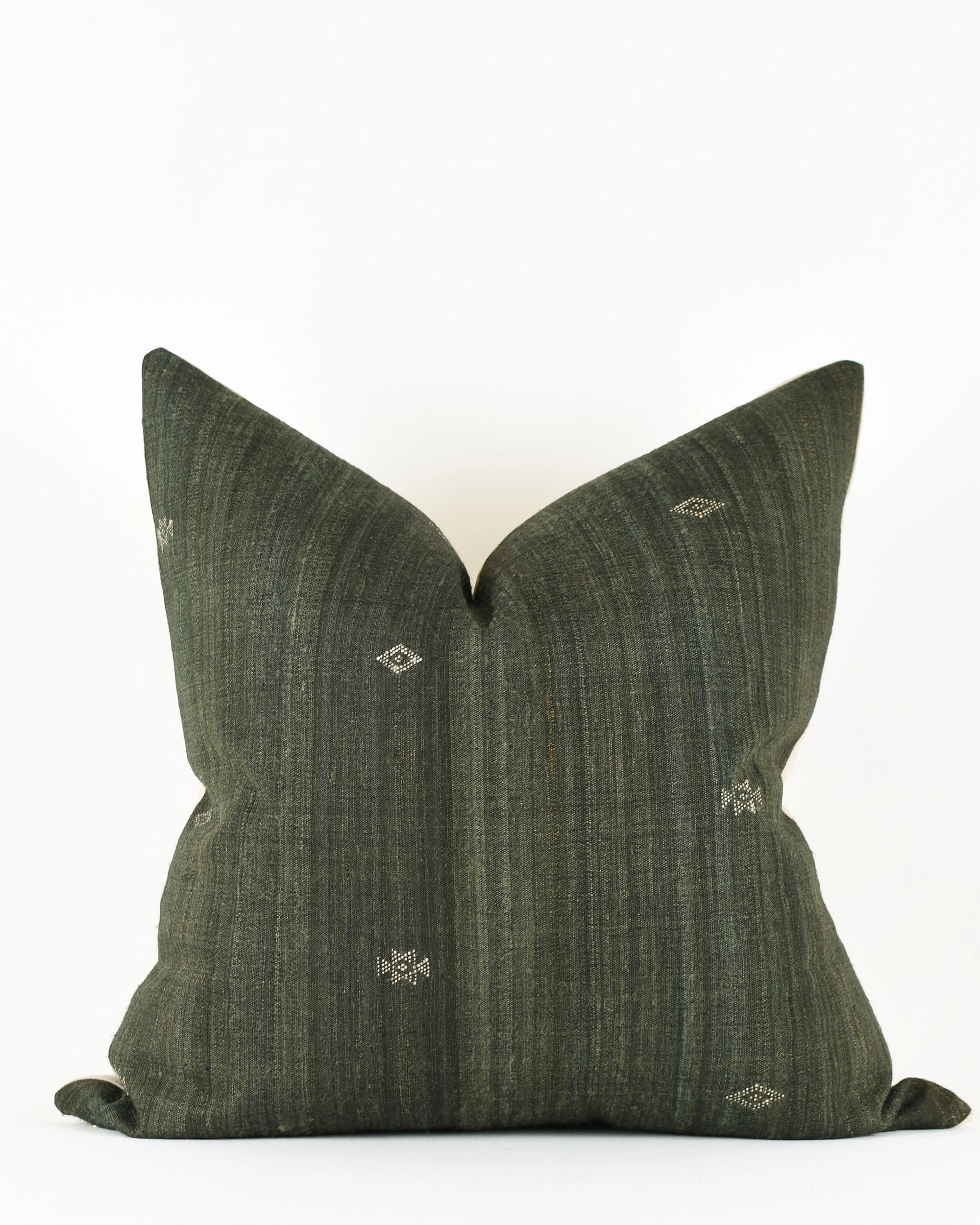 The Faire Dahlia Black 22x22 Pillow features handwoven Gujarat silk in dark green, with vertical stripes and small geometric embroidery, displayed on a plain white background.