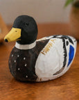 Hand-painted black basswood duck by Faire with carved details, perfect for adding rustic charm to home décor.