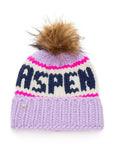 The Faire Knit Ski Hat is a luxury lavender beanie featuring a thick fold-over brim, white and pink stripes, bold navy "ASPEN" lettering, and topped with a large brown faux fur pom pom.