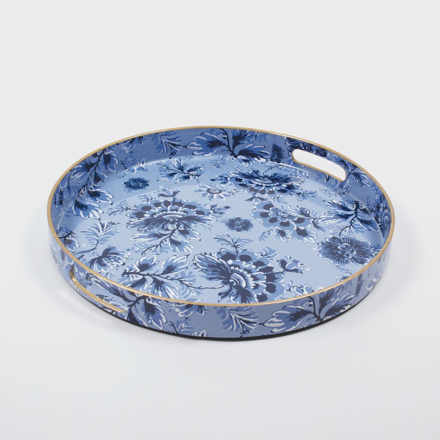 The Blue Rose Vanity Tray by Faire, a round serving piece with handles, features a blue floral pattern and elegant gold trim on a light gray background, ideal for stylish entertaining.