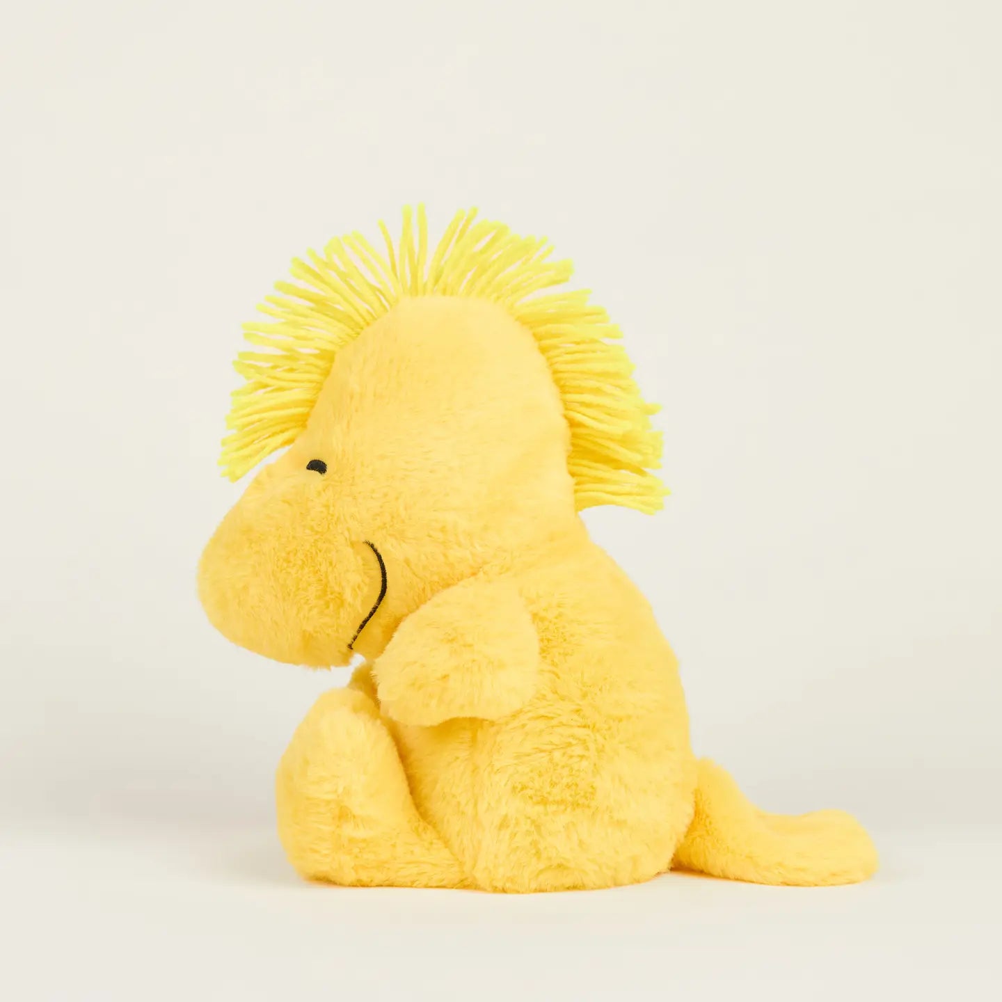 The Woodstock Warmies by Warmies/Intelex is a microwavable plush of Peanuts' yellow bird, featuring fuzzy fur, a yarn hair tuft, stitched black eyes, and a gentle lavender scent for comforting sensory relief.