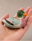 Pink hand-painted carved basswood duck by Faire held in hand, perfect rustic accent for Bungalow Furniture & Accessories.