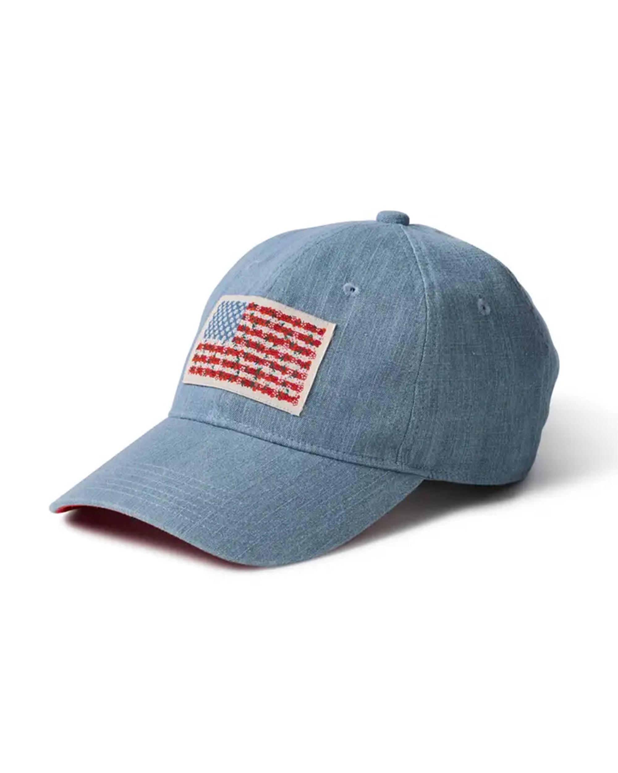 The Faire Americana Denim Baseball Cap features light blue denim, a front American flag patch with red, white, and blue embroidery, a curved brim, visible stitching, and an adjustable strap for comfort.
